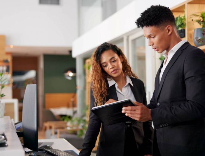 Reception, employees and tablet with teamwork, hotel and accommodation with cooperation. Coworkers, hospitality and service with tech, internet and digital app for schedule and reservation for lodge.